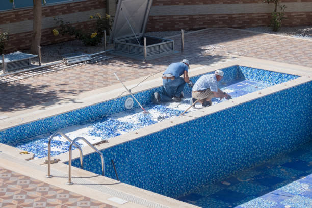 Workers smoothing pool surface during professional resurfacing project
