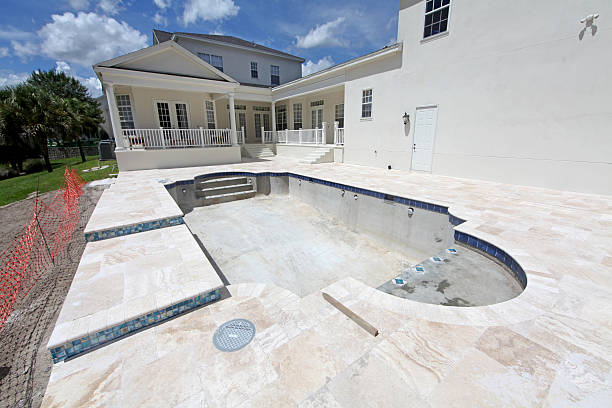 Pool renovation process removing old plaster and applying fresh finish<br />
