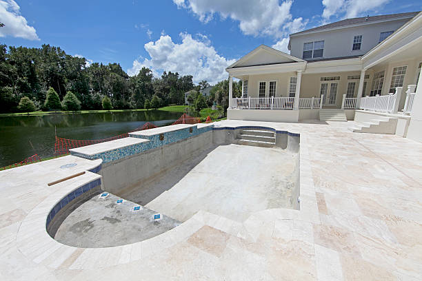 Skilled pool technician inspecting resurfaced pool for quality and safety in Florida residential setting