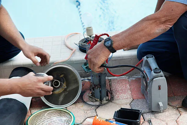 Technician diagnosing pool equipment connections and components in North Palm Beach, FL. Pool Equipment repair near me