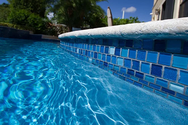 Blue tile waterline at a Wellington, FL pool kept warm and lit by Palm Beach Pool & Spa Services pool equipment repair.